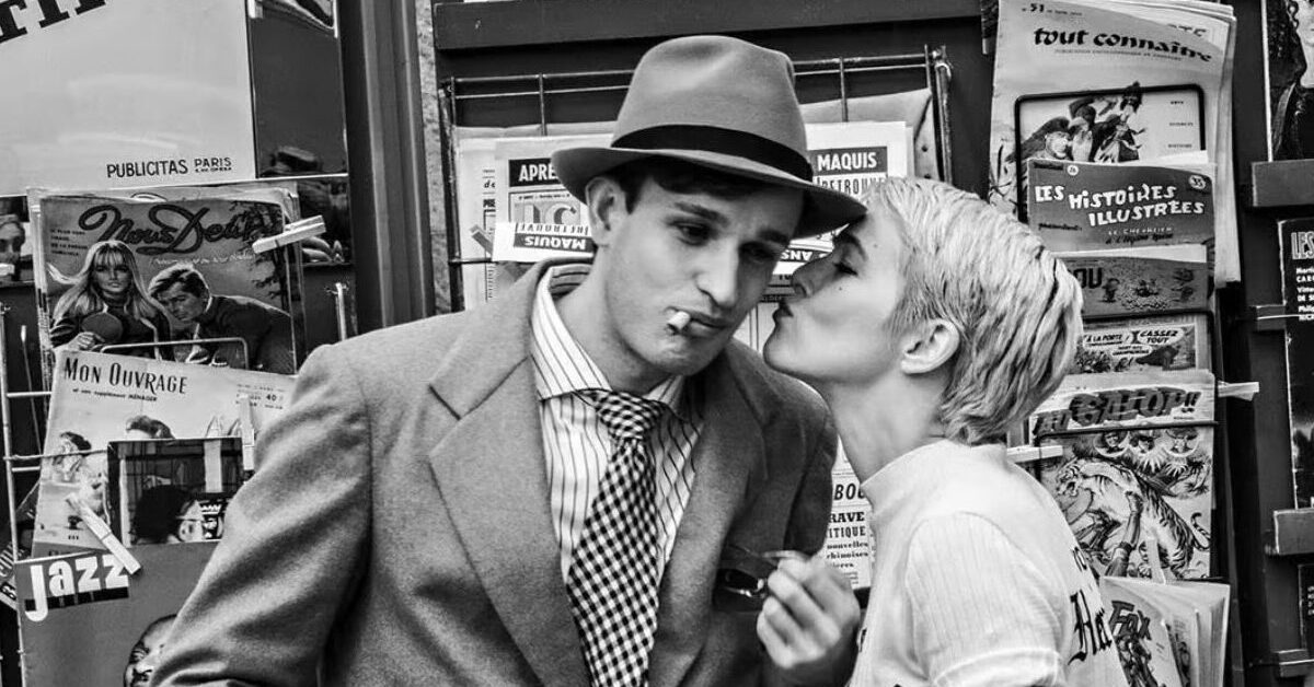 Zoey Deutch as Jean Seberg kisses Aubry Dullin as Jean-Paul Belmondo.